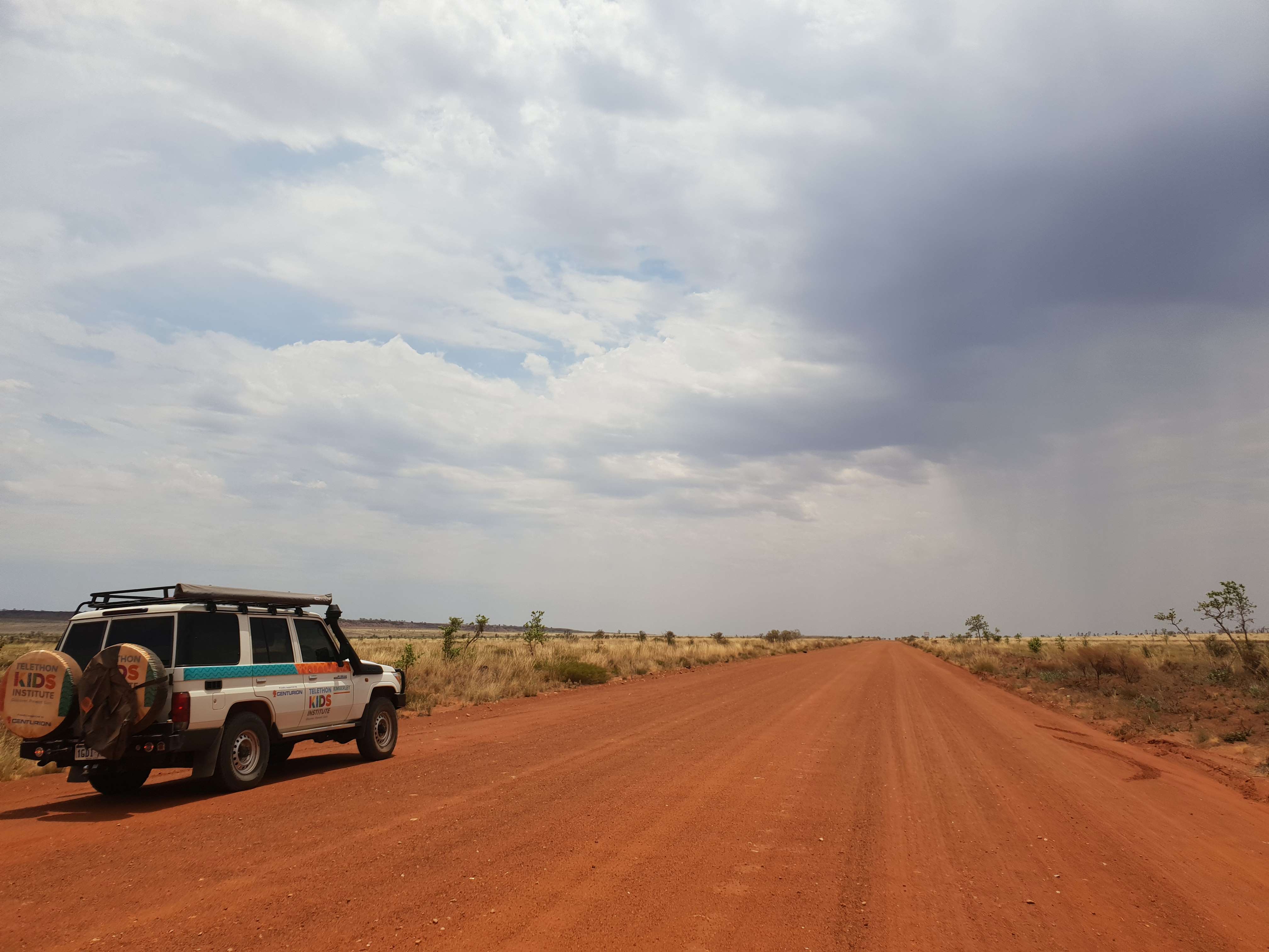 car driving on red dirt road